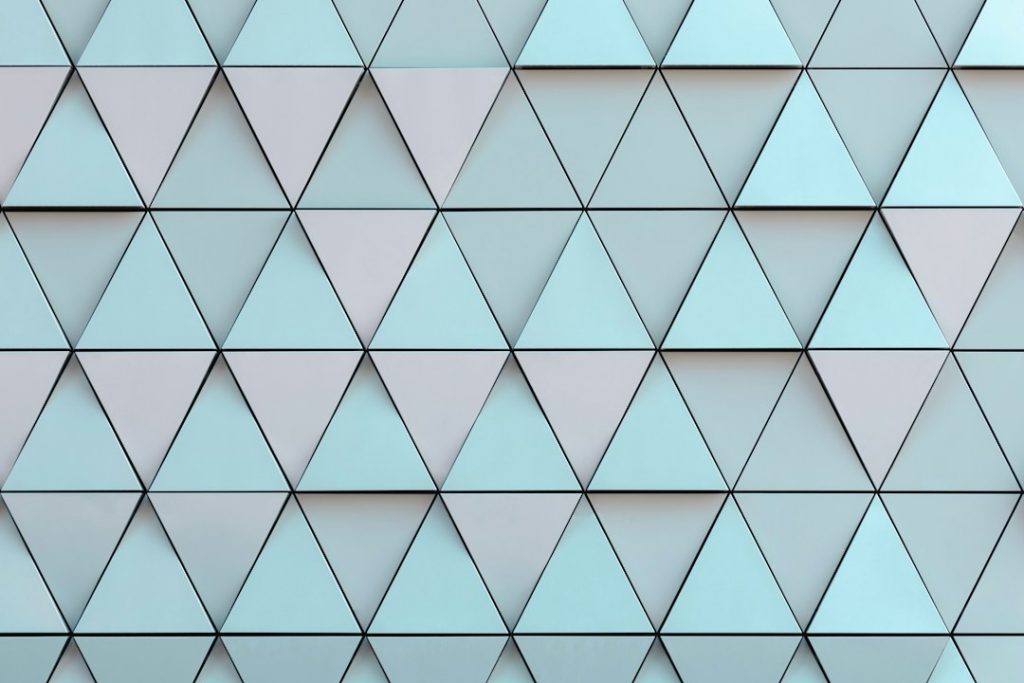A geometric wall pattern featuring rows of light blue and grey triangles arranged in a repeating, symmetrical grid. The design creates a modern, abstract appearance with clean lines and sharp angles.