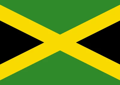 The flag of Jamaica features a diagonal yellow cross dividing four triangles: green on the top and bottom, and black on the left and right sides, symbolising the vibrant spirit of Jamaica.